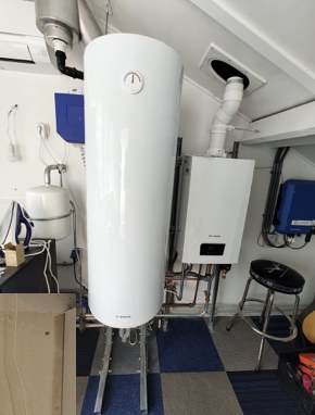Verticaal geplaatste warmwateraccu in een technische ruimte