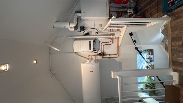 Horizontaal aan de muur gemonteerde warmwateraccu met kort koperen leidingwerk